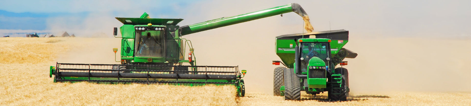An image of farming machinery operating in a wheat field.